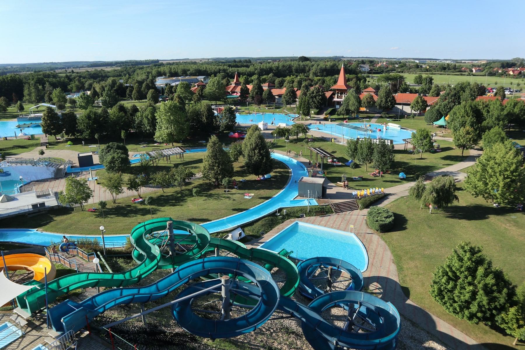 Aerial view of an aquatic facility: slides, lazy river, and multiple pool decks