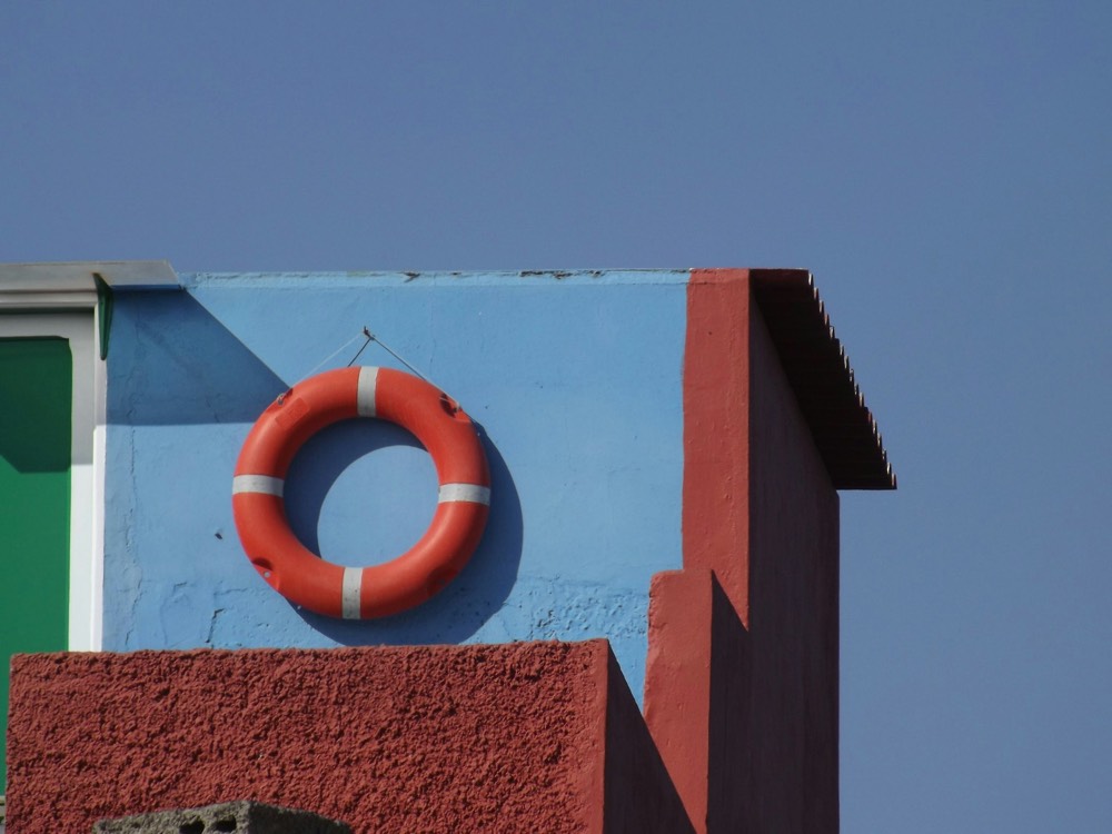 A ring buoy mounted on the wall of a pool house