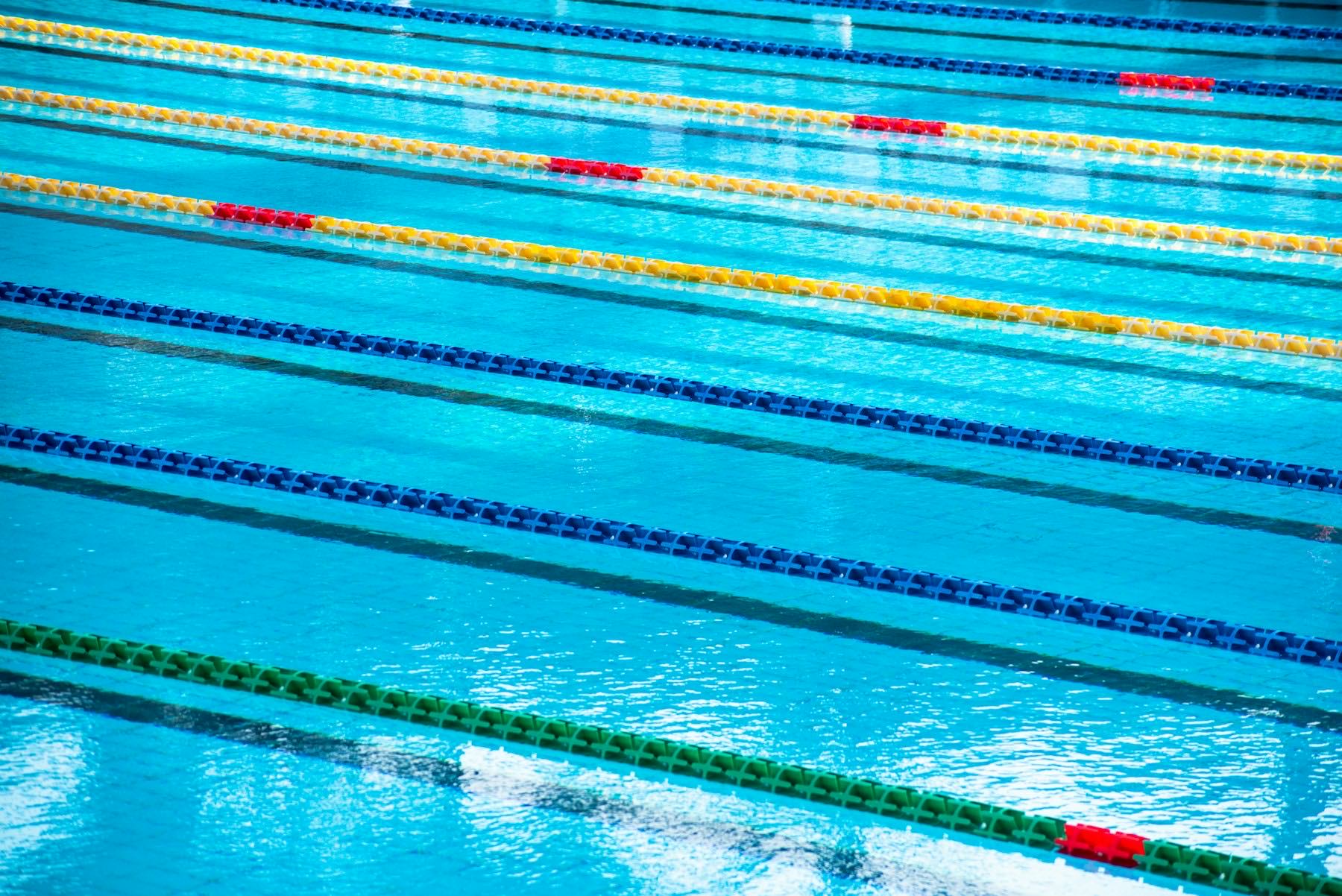 Swimming pool lane lines seen across still blue water